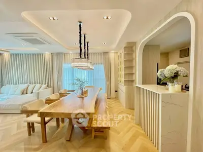 Luxurious open-plan living and dining area with elegant wooden table and modern decor.