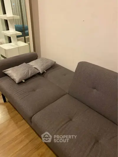 Modern living room with stylish gray sofa and wooden flooring, perfect for cozy relaxation.
