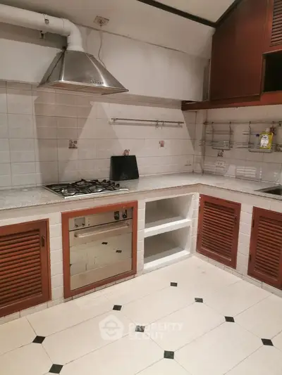 Spacious kitchen with gas stove and ample storage in modern real estate listing.