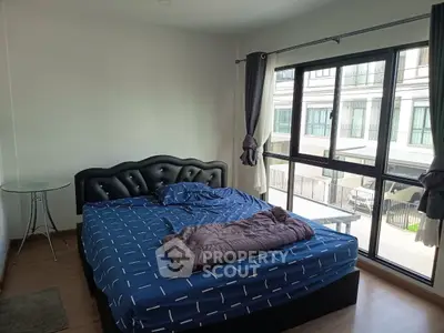 Spacious bedroom with large windows and modern decor in a stylish apartment.