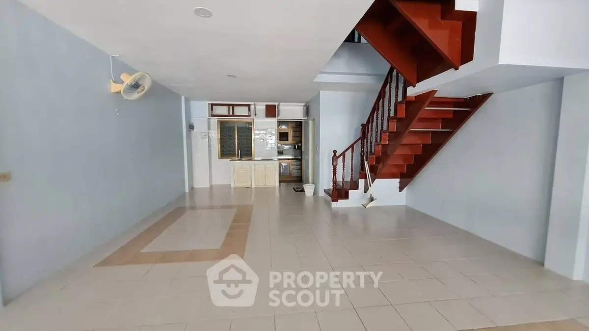 Spacious open-plan living area with staircase and tiled flooring