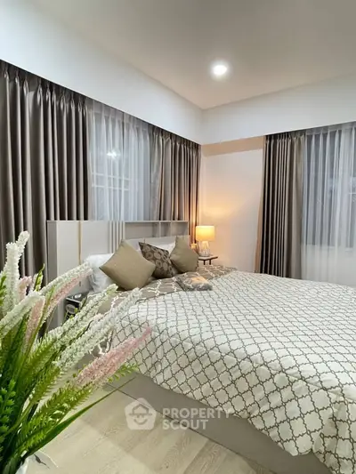 Elegant bedroom with stylish decor and cozy ambiance, featuring large windows and soft lighting.