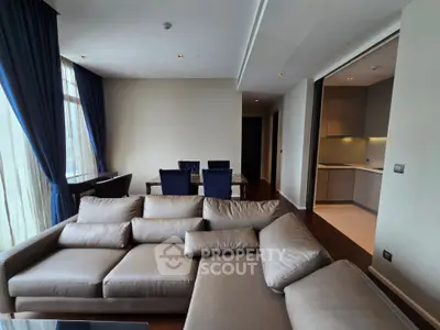 Spacious modern living room with elegant sofa and dining area, featuring large windows and stylish curtains.