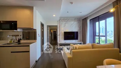 Modern living room with open kitchen and city view, featuring sleek design and natural light.