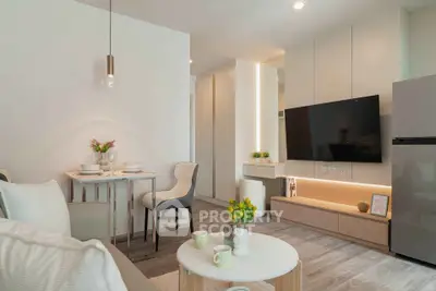 Modern living room with sleek furniture and wall-mounted TV in a stylish apartment.