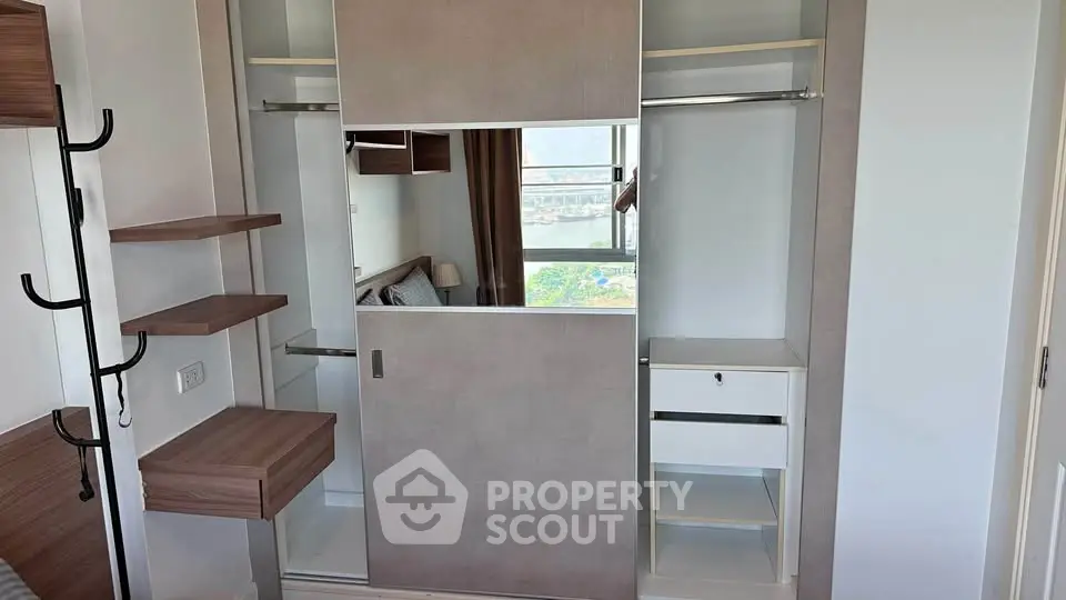 Modern bedroom with built-in wardrobe and city view, showcasing sleek design and ample storage space.