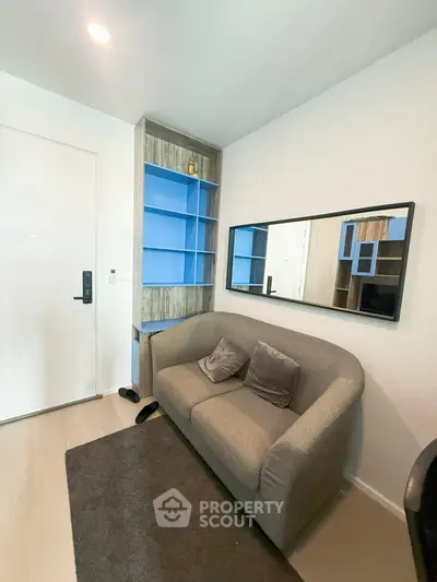 Cozy living room with modern sofa and built-in shelving, perfect for urban living.