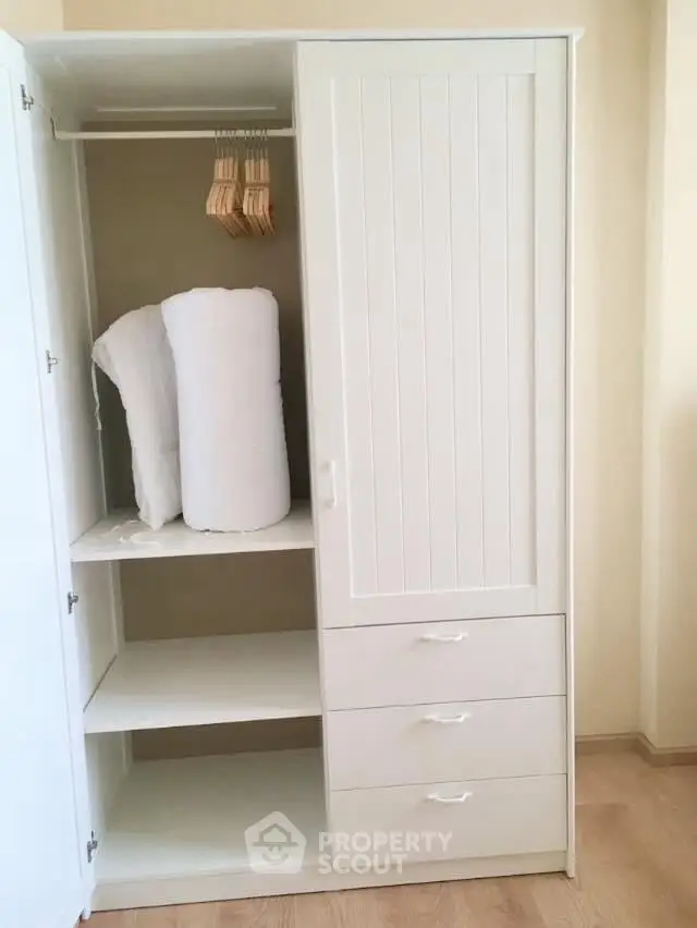 Spacious white wardrobe with shelves and hangers in modern interior