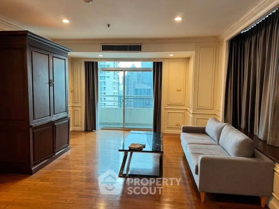 Spacious living room with elegant wooden flooring and city view balcony.