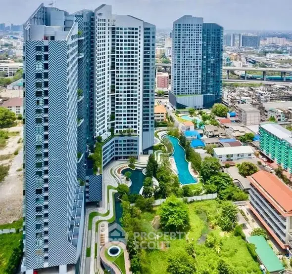 Stunning aerial view of modern high-rise buildings with lush gardens and pool in urban setting.