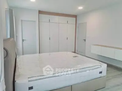 Spacious modern bedroom with large bed and built-in wardrobe