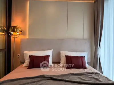 Luxurious bedroom with elegant lighting and plush bedding in modern apartment.