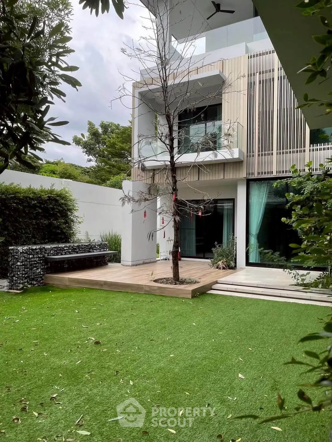 Modern home exterior with lush garden and sleek architectural design, featuring large windows and a minimalist aesthetic.