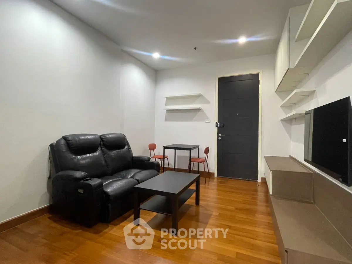 Modern living room with sleek furniture and wooden flooring, perfect for cozy gatherings.