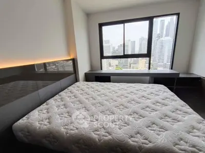 Spacious bedroom with city view, featuring a large bed and modern furnishings.