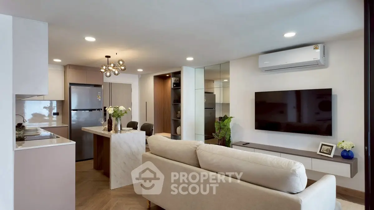 Modern living room with open kitchen, stylish decor, and sleek appliances in a cozy apartment.