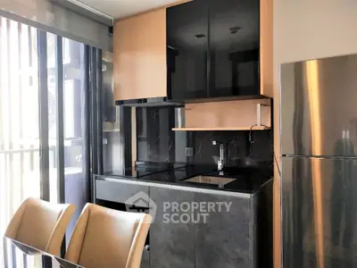 Modern kitchen with sleek cabinets and stainless steel fridge in a bright apartment.