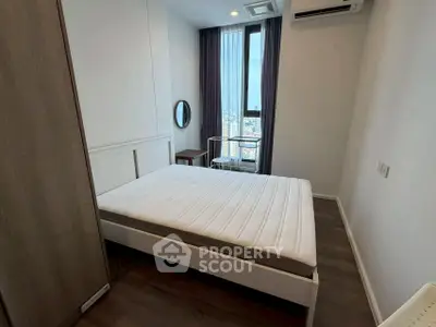 Modern bedroom with large window and city view, featuring a minimalist design and air conditioning.