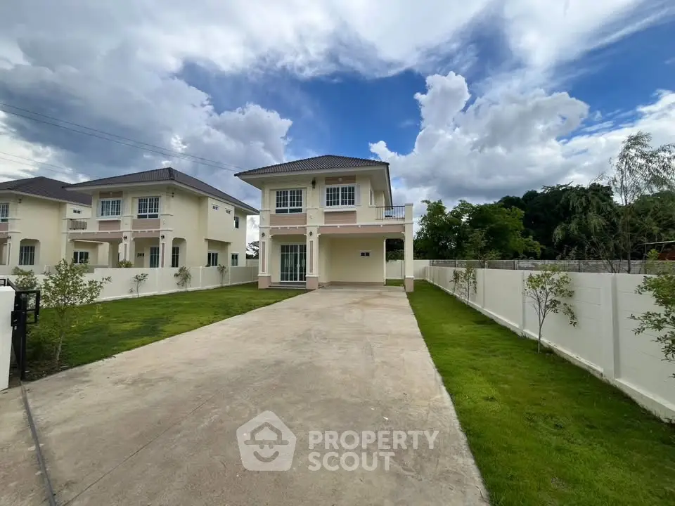 Stunning two-story house with spacious driveway and lush green lawn under a vibrant sky.