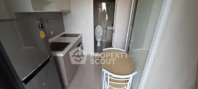 Compact kitchen with modern appliances and dining area in cozy apartment