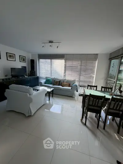 Spacious living room with modern decor and abundant natural light