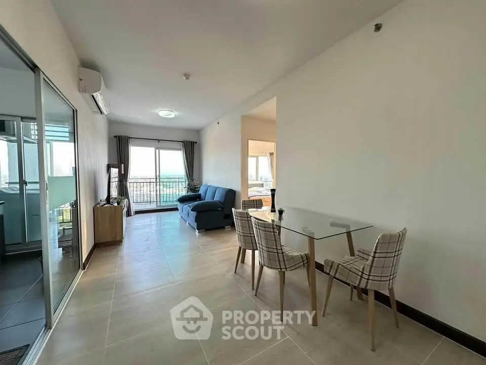 Spacious modern living room with glass dining table and balcony view