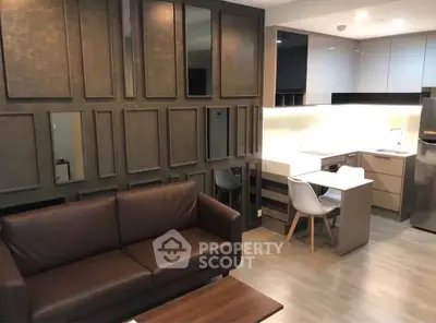 Modern living room with stylish kitchen in open layout, featuring sleek furniture and contemporary design.
