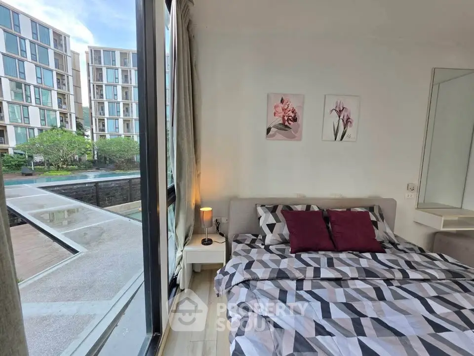 Modern bedroom with large window offering a stunning view of contemporary apartment complex.