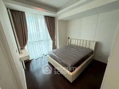 Modern bedroom with elegant design and large window offering natural light