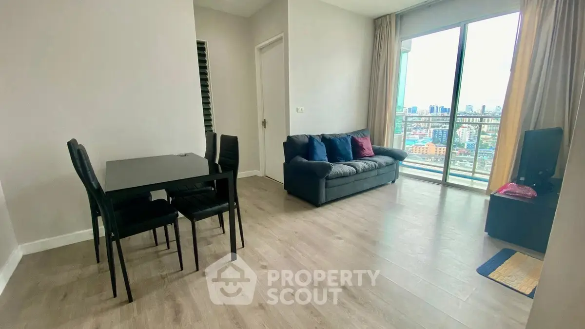 Modern living room with city view, featuring sleek furniture and large windows for natural light.
