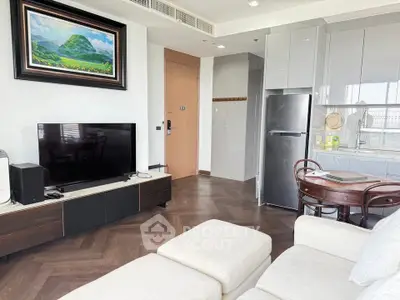 Modern living room with sleek furniture and open kitchen layout in a stylish apartment.