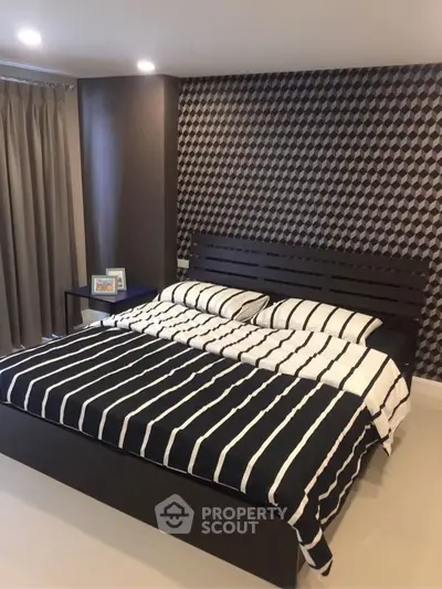 Modern bedroom with stylish wallpaper and cozy bedding