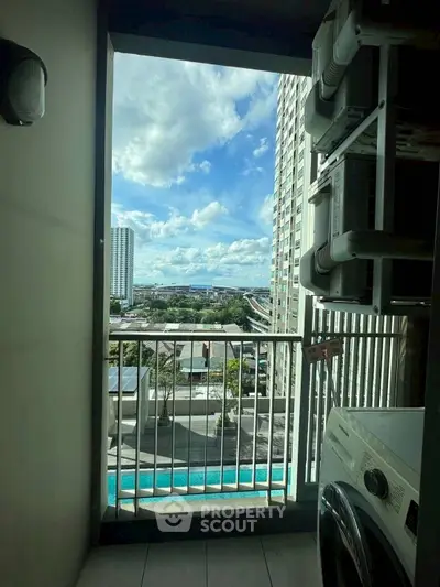 Stunning balcony view with cityscape and pool, featuring modern laundry appliances.