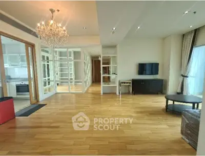 Spacious living room with elegant chandelier and wooden flooring