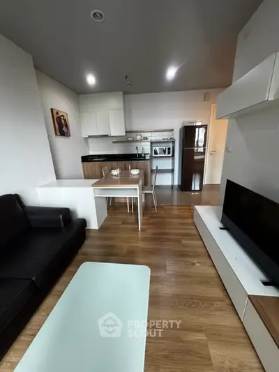 Modern open-plan living room with sleek kitchen and cozy seating area.