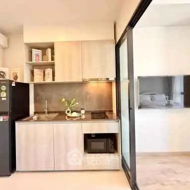 Modern compact kitchen with sleek cabinetry and built-in appliances in a stylish apartment.