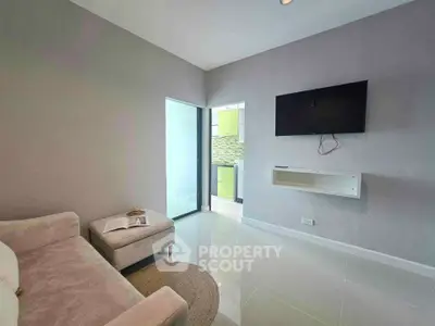 Modern living room with wall-mounted TV and cozy seating area