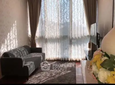 Elegant living room with large window and stylish decor, perfect for relaxation and entertaining.