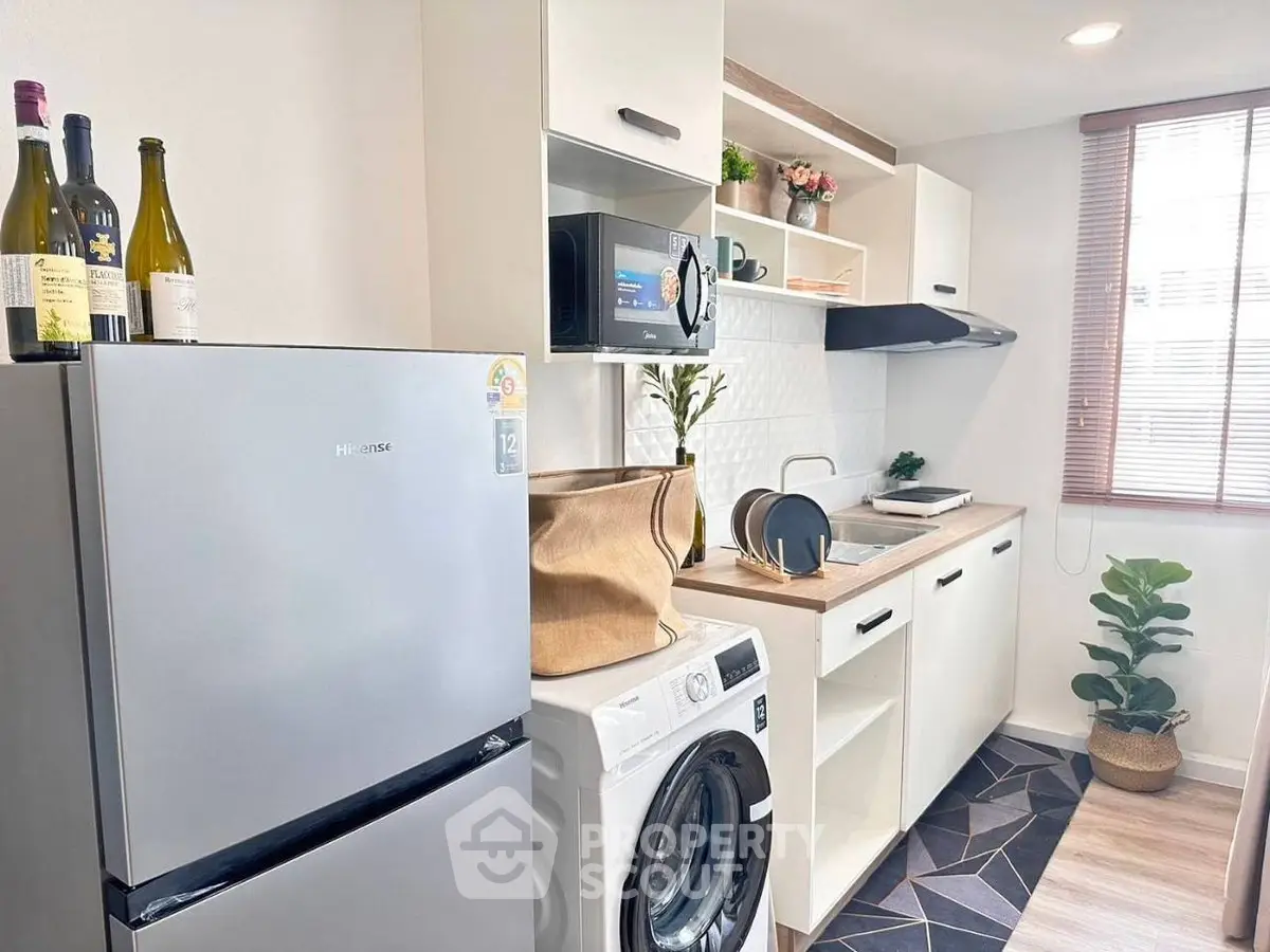 Modern kitchen with washing machine and sleek appliances in bright interior