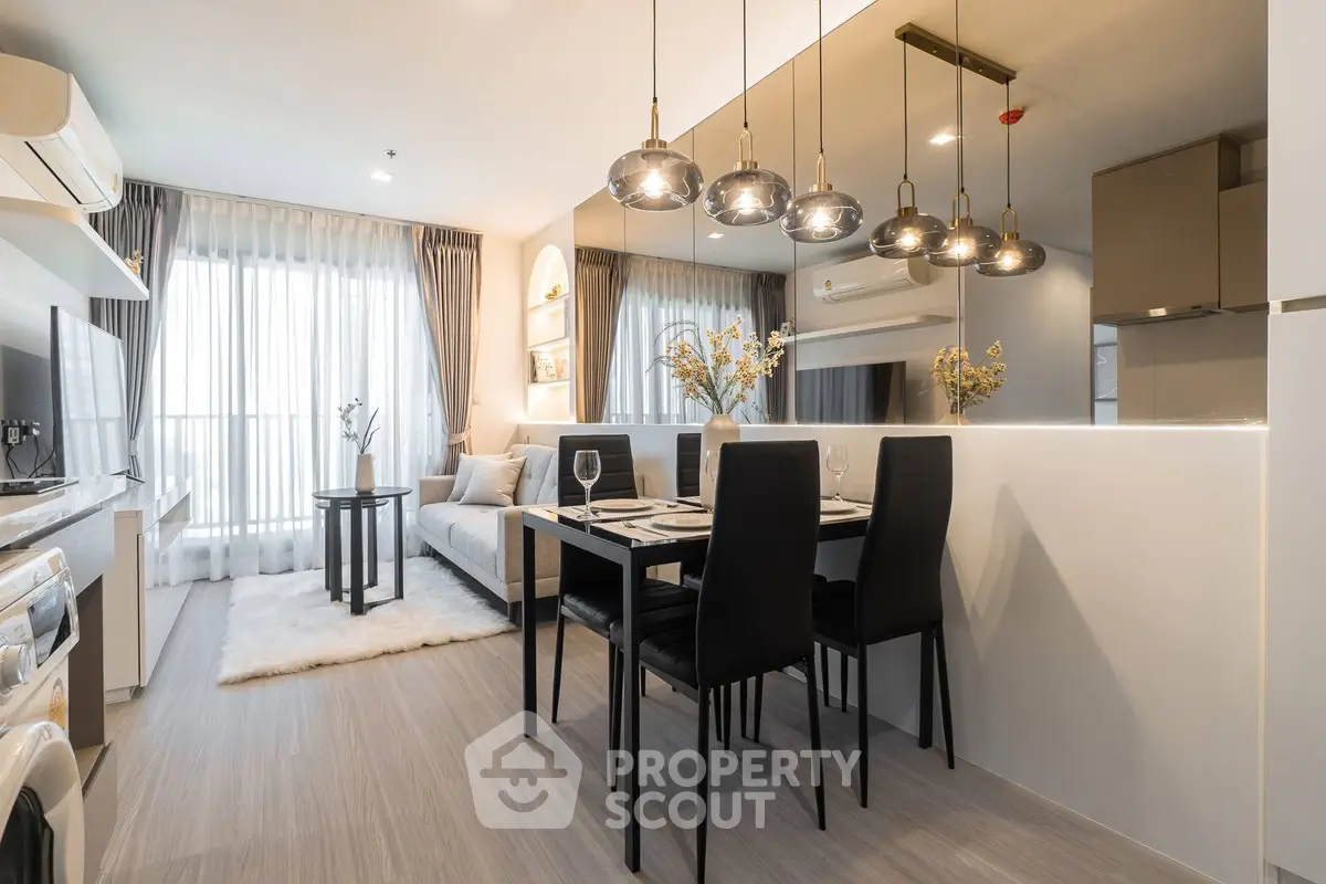 Modern open-plan living room and dining area with stylish lighting and cozy decor.