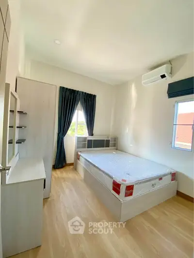 Bright and airy bedroom with modern furnishings and large windows in a stylish apartment.
