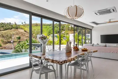 Luxurious open-plan living room with stunning pool and garden view, featuring modern furniture and elegant decor.