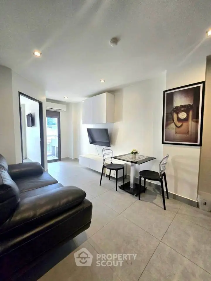 Modern living room with sleek furniture and wall-mounted TV in a stylish apartment.