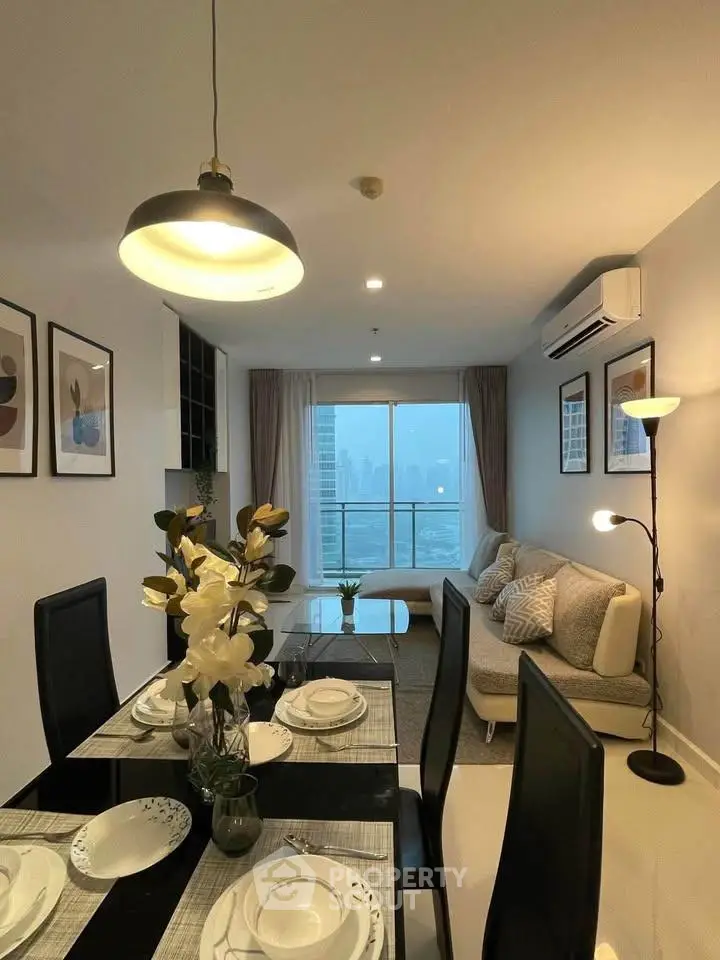 Modern living room with dining area and city view, featuring elegant decor and cozy ambiance.