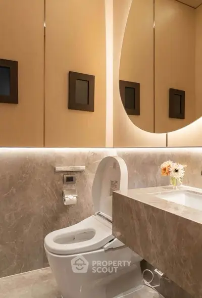 Luxurious modern bathroom with elegant marble finishes and ambient lighting.