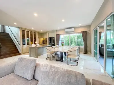 Spacious open-plan living and dining area with modern kitchen and large windows.