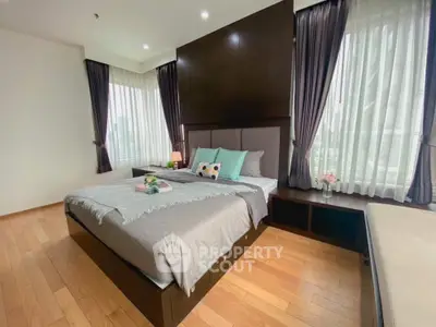 Spacious bedroom with elegant decor and large windows for natural light.