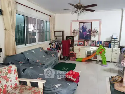 Spacious living room with eclectic decor and ceiling fan, featuring a cozy seating area and playful children's slide.