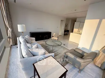 Luxurious modern living room with elegant furniture and large windows offering natural light.