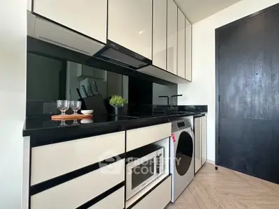 Modern kitchen with sleek cabinetry, built-in microwave, and washing machine in a stylish apartment.